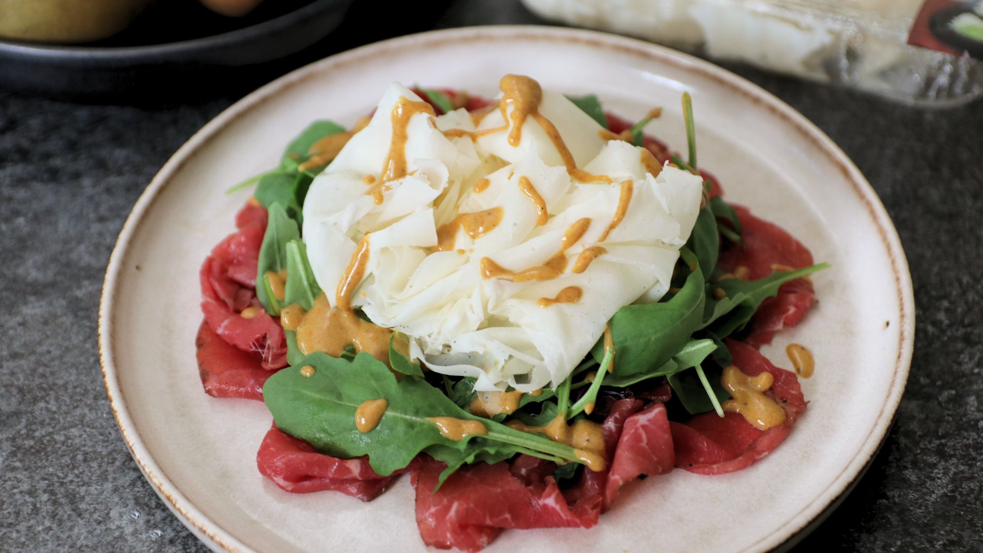Carne salada con rucola, citronette alla senape e Raspadura Bella Lodi