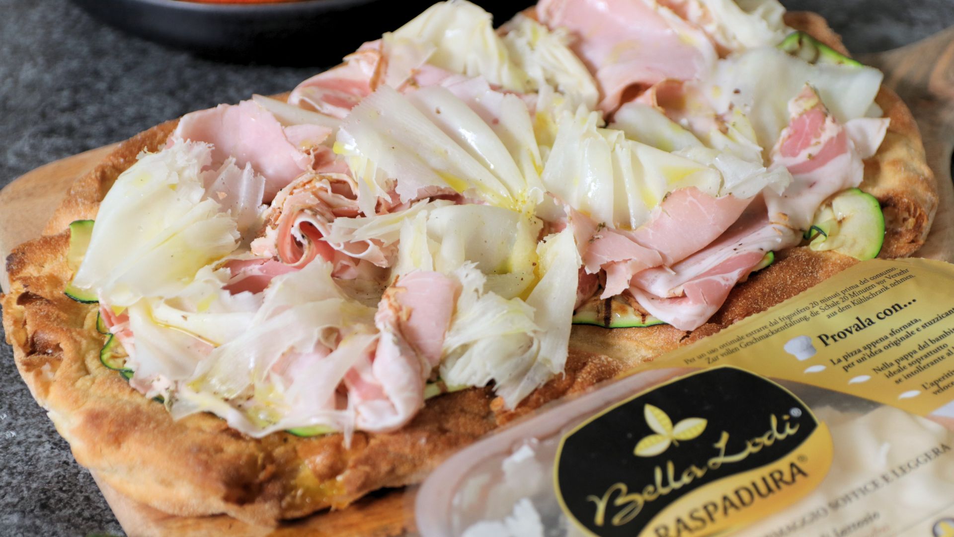 Pinsa con zucchine grigliate, porchetta, citronette al limone e Raspadura Bella Lodi