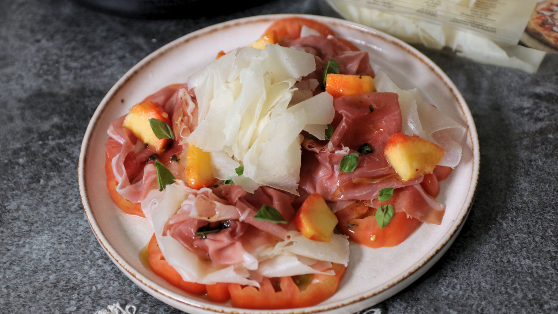 Carpaccio di pomodoro con Raspadura Bella Lodi, prosciutto crudo e pesca con vinaigrette balsamica